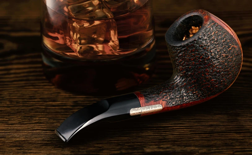 a pipe sitting on top of a wooden table next to a glass, inspired by George Jamesone, black and terracotta, rich details full of texture, riffle, posing