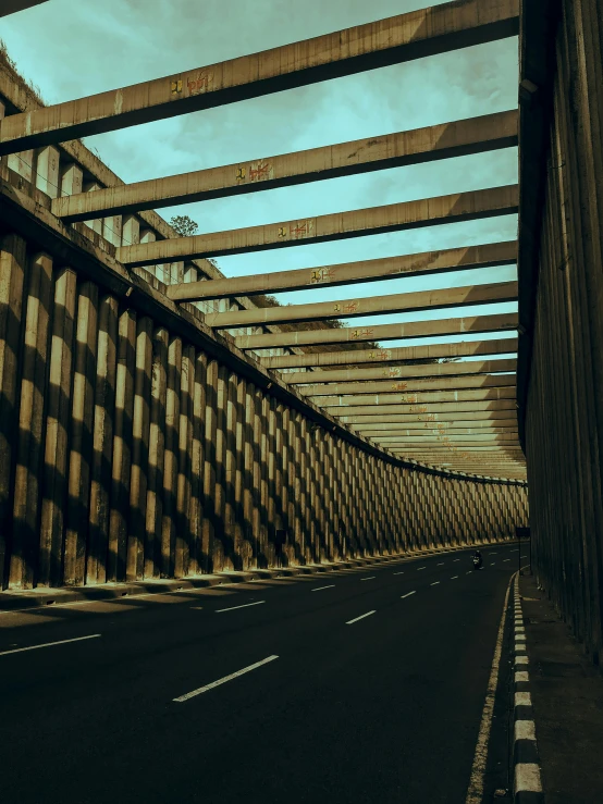 a view of a bridge from the side of the road, an album cover, inspired by Filip Hodas, pexels contest winner, brutalism, interior wood, colonnade, beige and dark atmosphere, symmetrical image