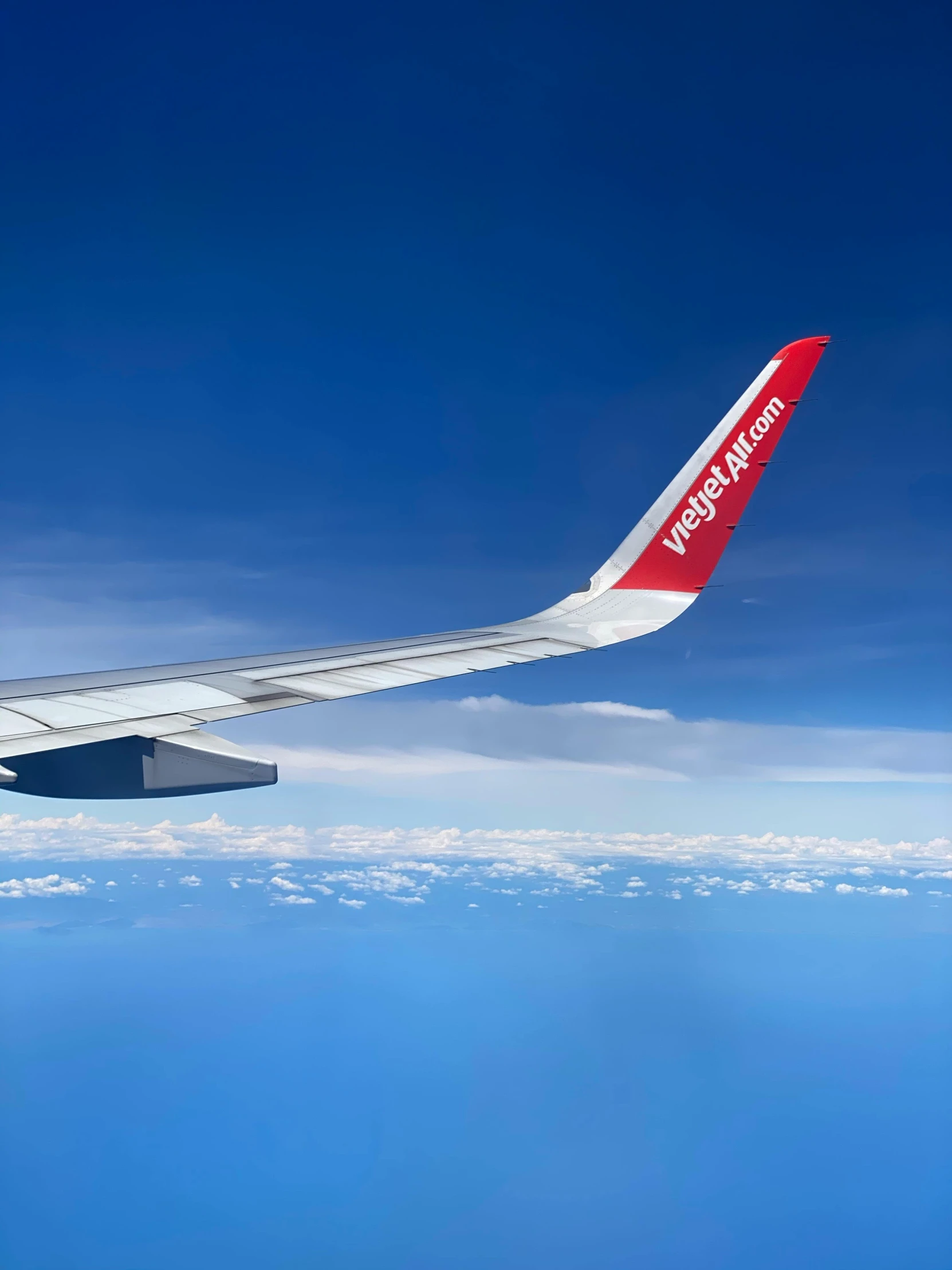 the wing of an airplane flying above the clouds, by Bernie D’Andrea, visual art, curved red arrow, norwegian, profile image, taken in 2022