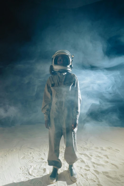 a man in a space suit standing in the middle of a desert, inspired by ridley scott, pexels contest winner, light and space, in front of dark smoke, 1 9 6 0 s space girl, covered in white flour, lunar themed attire