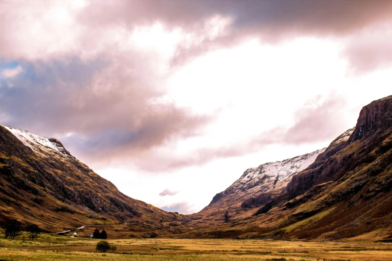 a herd of sheep grazing on top of a lush green field, by Peter Churcher, pexels contest winner, hurufiyya, snowy craggy sharp mountains, scottish highlands, autumn colours, in between a gorge