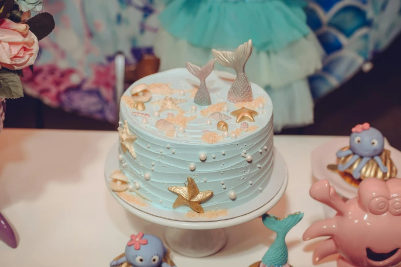 a cake sitting on top of a white table, a cartoon, by Julia Pishtar, pexels contest winner, mermaids, parties, blueish, japanese