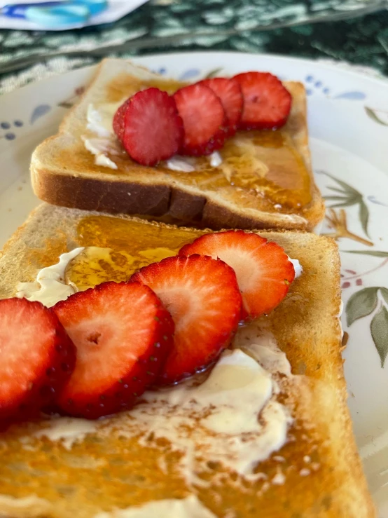two slices of french toast with strawberries on a plate, a portrait, by Tom Wänerstrand, unsplash, maple syrup sea, taken on iphone 14 pro, summer afternoon, competition winning