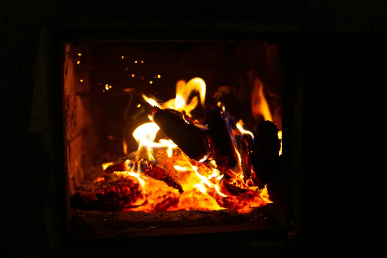 a close up of a fire in a fireplace, pexels contest winner, instagram post, fireflys, warm coloured, a wooden
