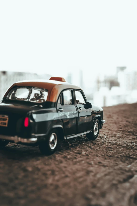 a toy car sitting on top of a dirt road, a tilt shift photo, pexels contest winner, hypermodernism, taxi, profile pic, square, preserved historical