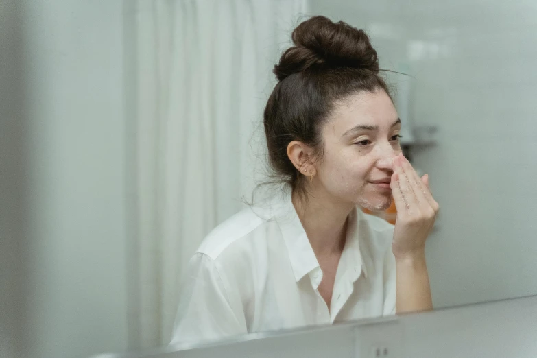 a woman brushing her teeth in front of a mirror, pexels contest winner, drinking cough syrup, glowing peach face, woman crying, in front of a computer