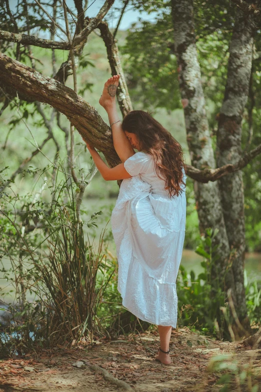 a woman in a white dress standing next to a tree, inspired by Nell Dorr, pexels contest winner, renaissance, picking flowers, hanging upside down, young southern woman, back
