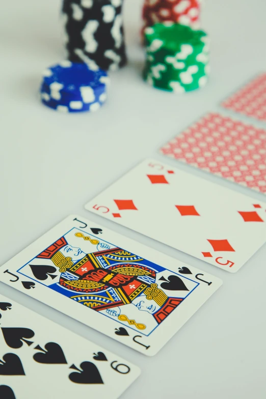 a group of playing cards sitting on top of a table, a screenshot, by Jacob Toorenvliet, pexels contest winner, square, faceted, colored dots, tall thin