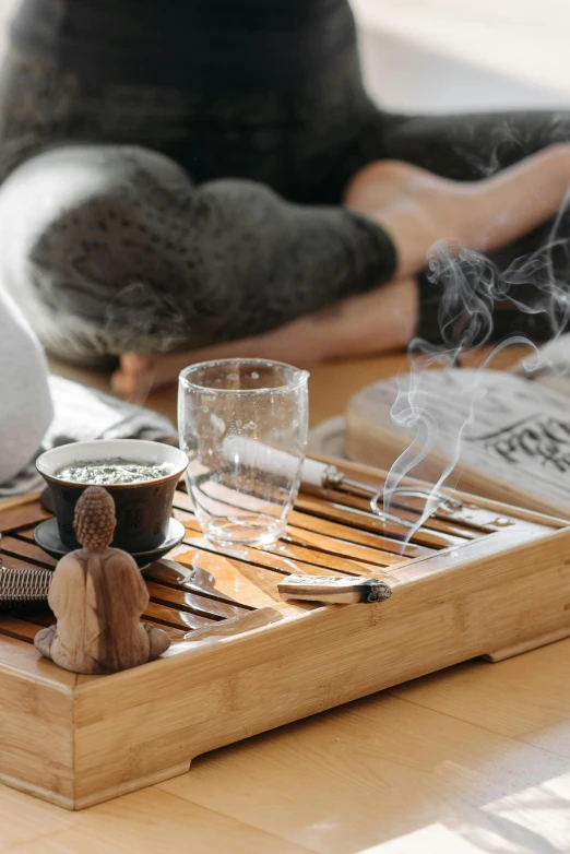 a person sitting on the floor in a yoga pose, trending on pexels, process art, on a wooden tray, drinking and smoking, bamboo, couple on bed