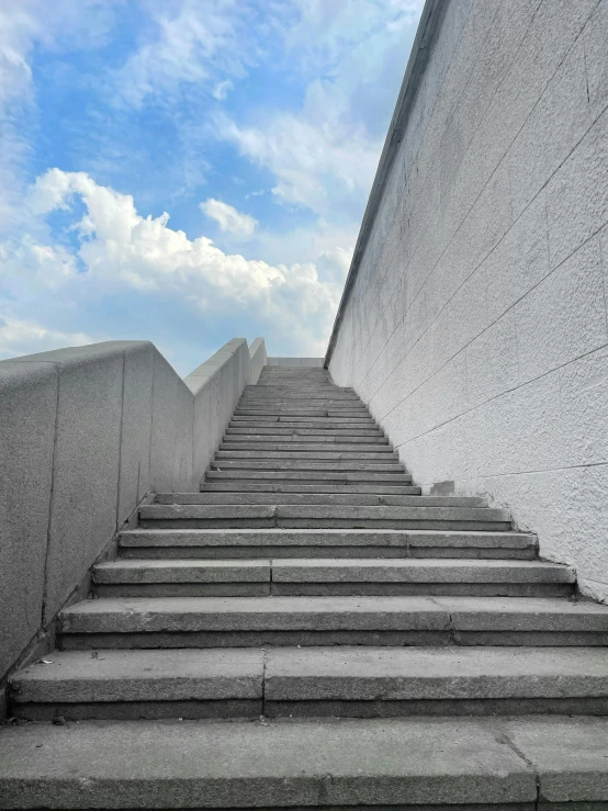 a set of stairs going up the side of a building, inspired by Tadao Ando, unsplash, brutalism, skies behind, today\'s featured photograph 4k, low quality photo, untethered stelae