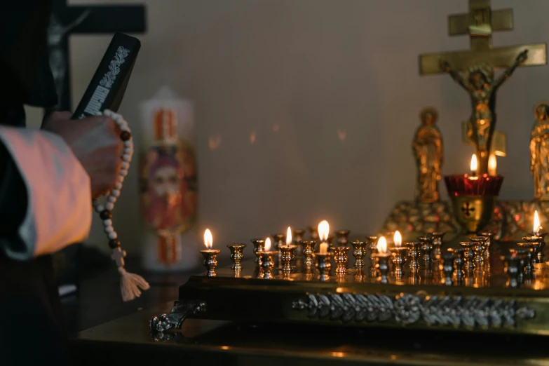 a person standing in front of a bunch of candles, religious sculpture, profile image, decorations, on a candle holder