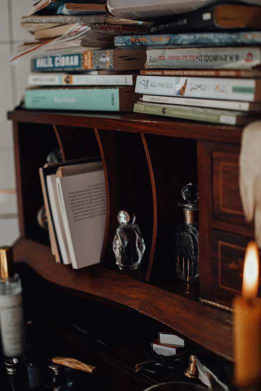a stack of books sitting on top of a wooden shelf, holding a candle holder, cabinet of curiosities, story telling aesthetic, studyng in bedroom