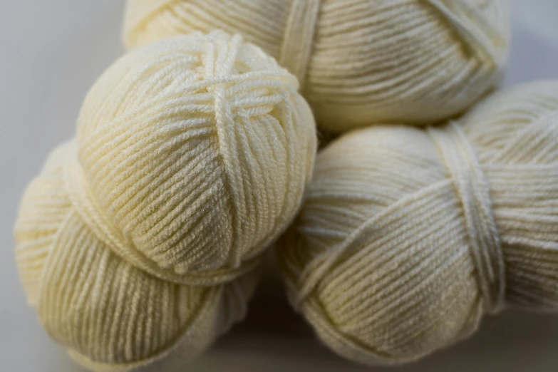 a pile of balls of yarn sitting on top of a table, cream, medium close shot, fan favorite, exterior shot