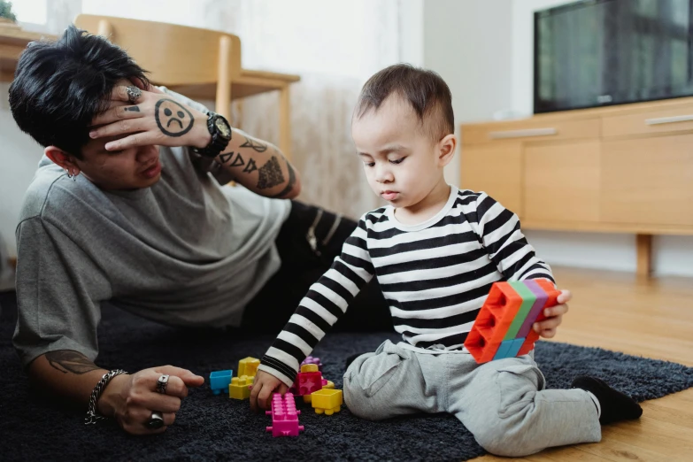 a man playing with a child on the floor, pexels contest winner, building blocks, looking confused, healthcare, te pae