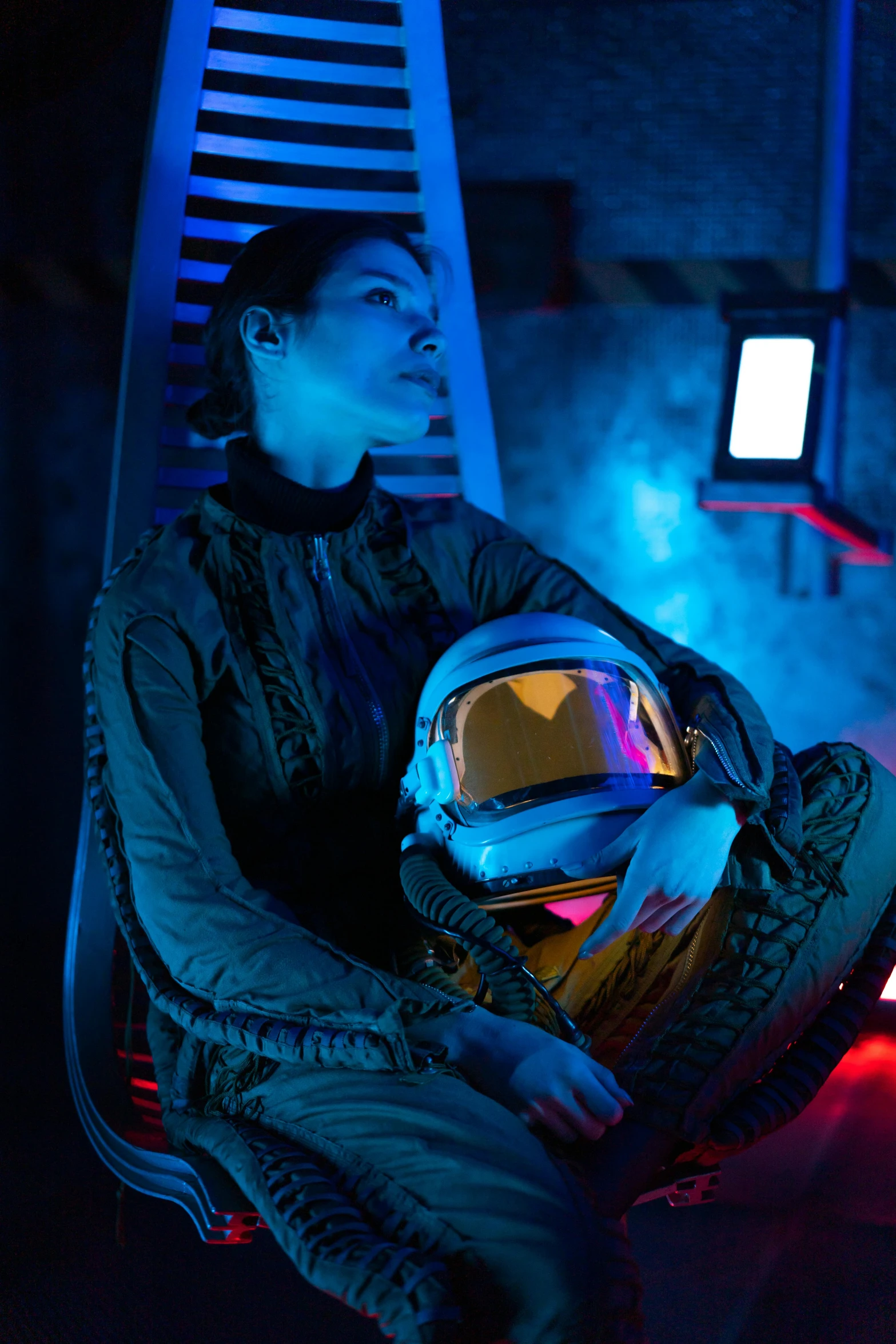 a woman sitting in a chair with a helmet on, scene in space, lena oxton, promotional image, glow