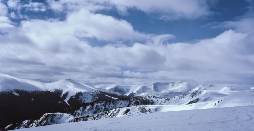 a person riding skis on top of a snow covered slope, pexels contest winner, hurufiyya, large white clouds, 1990's photo, highlands, (3 are winter