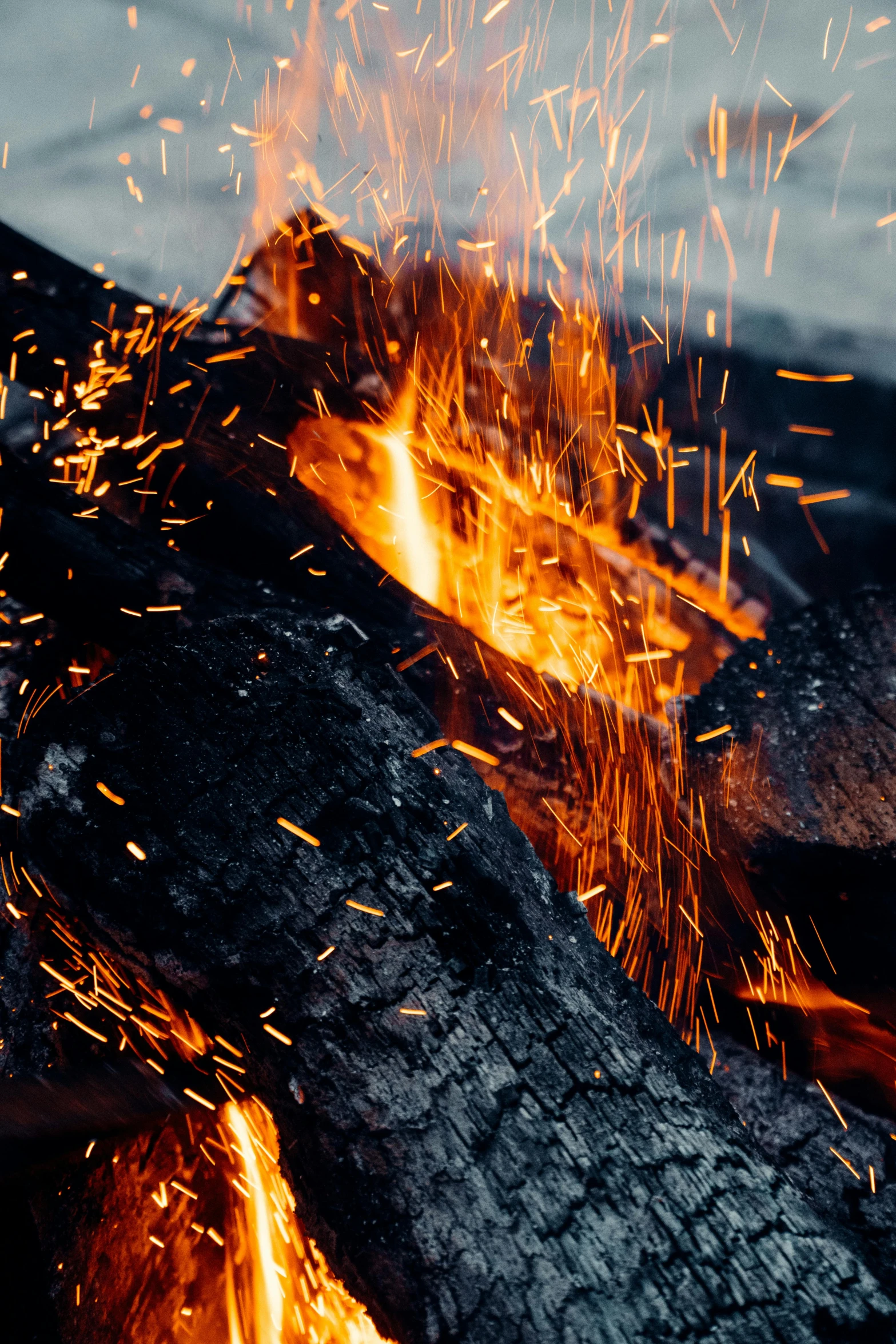 a close up of a fire with sparks coming out of it, by Adam Marczyński, smouldering charred timber, a cozy, vanilla, profile image