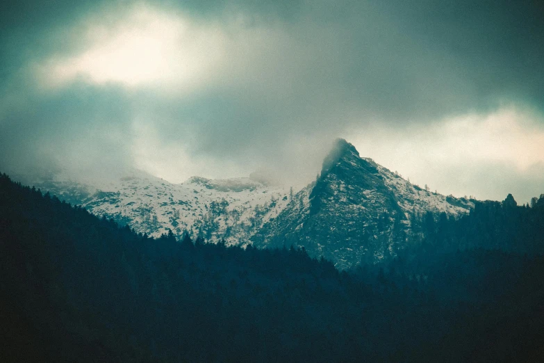 a mountain covered in snow under a cloudy sky, inspired by Elsa Bleda, unsplash contest winner, romanticism, dramatic ”