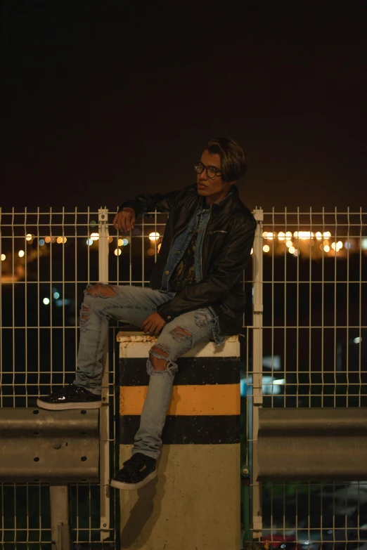 a man sitting on top of a cement block, pexels, happening, wearing leather jacket, mid night, androgynous person, mohamed chahin