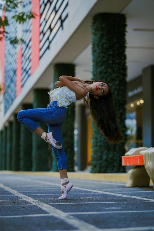 a woman standing on one leg in the air, by Briana Mora, pexels contest winner, at a mall, portrait of zendaya, crouching, denim