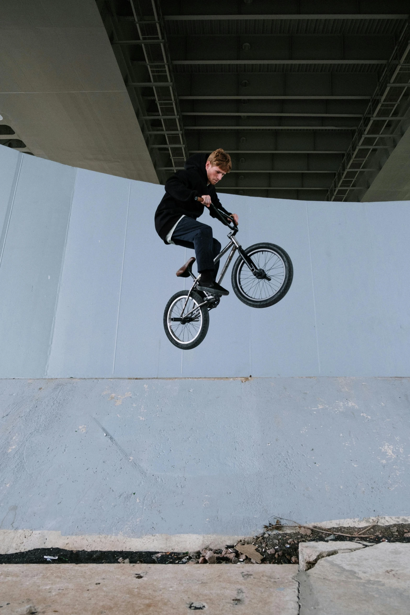 a man flying through the air while riding a bike, inspired by Seb McKinnon, overpass, headshot, low quality photo, on a wall