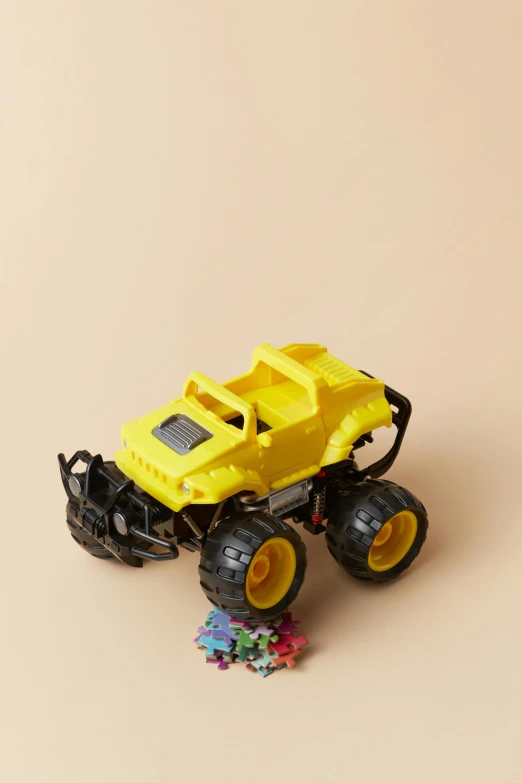 a yellow toy truck sitting on top of a table, a picture, off-roading, multicoloured, zoomed out, product shot