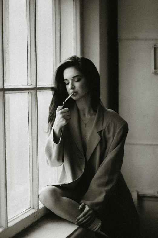 a woman sitting on a window sill brushing her teeth, a black and white photo, unsplash, surrealism, monica bellucci, cigars, wearing a blazer, kendall jenner