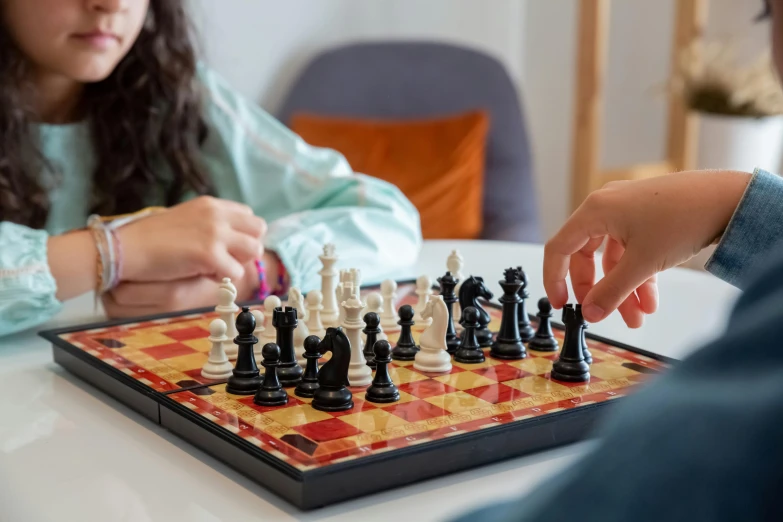 a couple of kids playing a game of chess, pexels contest winner, back of hand on the table, profile image, thumbnail, at home