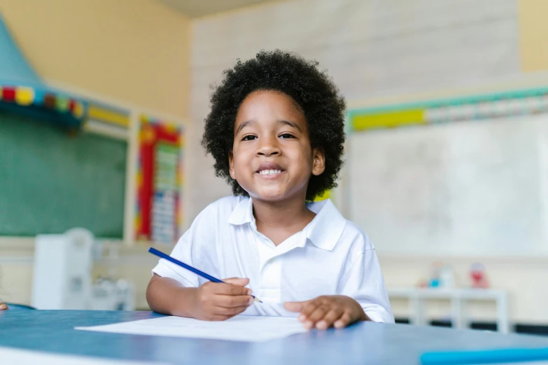 a little boy sitting at a desk with a pencil in his hand, pexels, ashcan school, a black man with long curly hair, school uniform, a still of a happy, 1 2 9 7