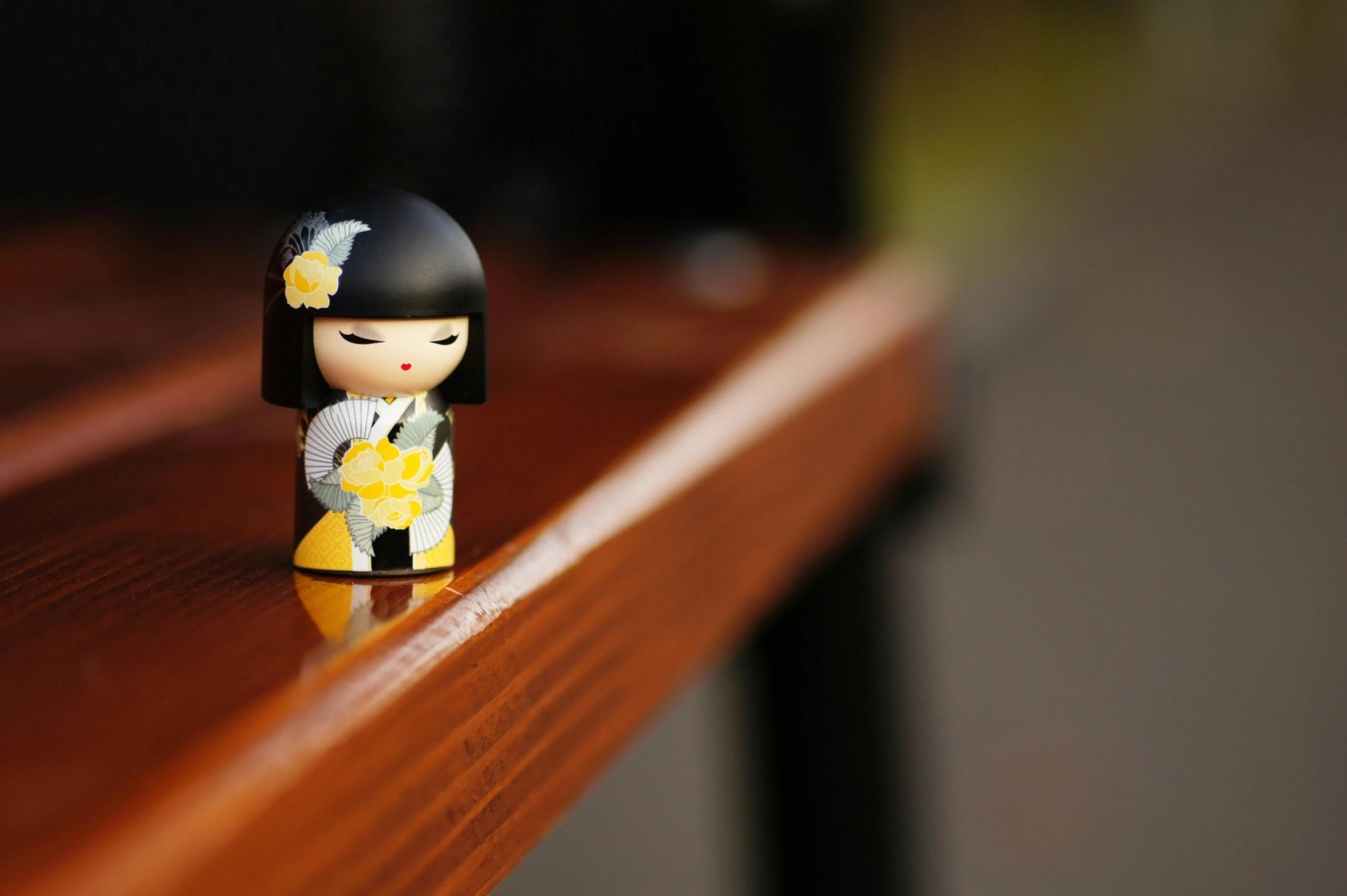 a small doll sitting on top of a wooden table, inspired by Nara Yoshitomo, unsplash, mingei, highly polished, with yellow flowers around it, waifu, kotegawa yui