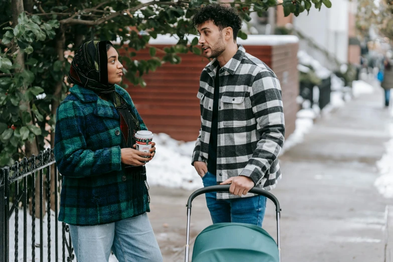 a man and woman walking down a sidewalk with a stroller, inspired by Myles Birket Foster, trending on pexels, wearing teal beanie, avan jogia angel, flannel, calmly conversing 8k