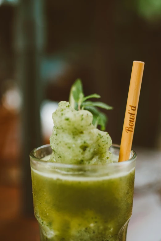 a green drink sitting on top of a wooden table, holding a wooden staff, slush!!, dwell, banner