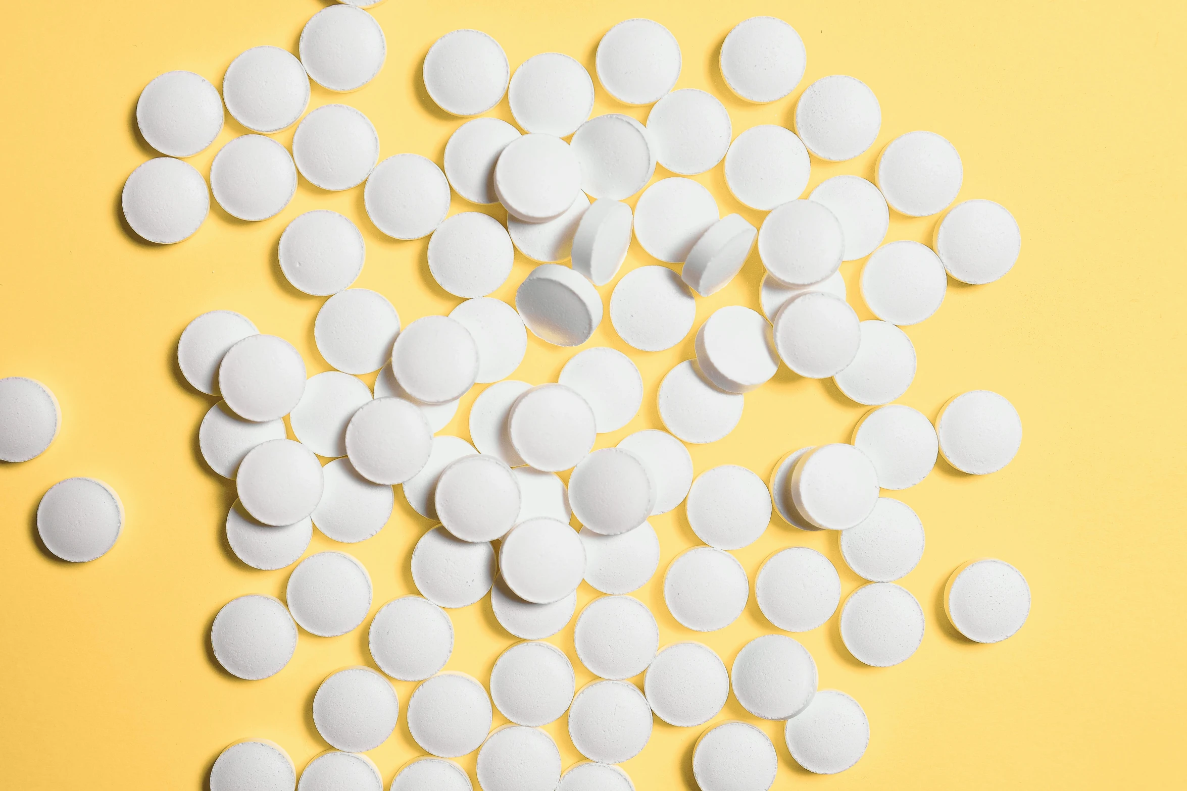 a pile of white pills on a yellow background, by Évariste Vital Luminais, trending on pexels, sweat drops, white panels, dezeen, hdpe