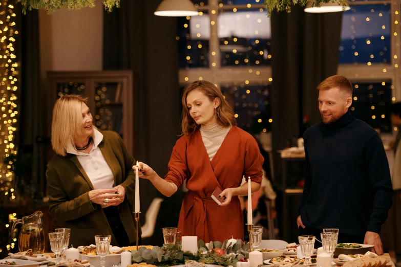 a group of people standing around a dinner table, hygge, profile image, decorations, professional image