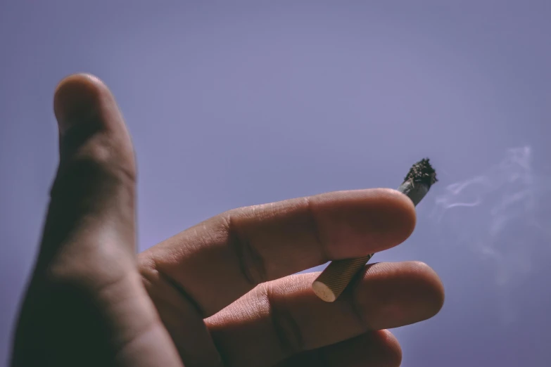 a person holding a cigarette in their hand, pexels contest winner, blue and purple vapor, hyperdetailed!, high quality product image”