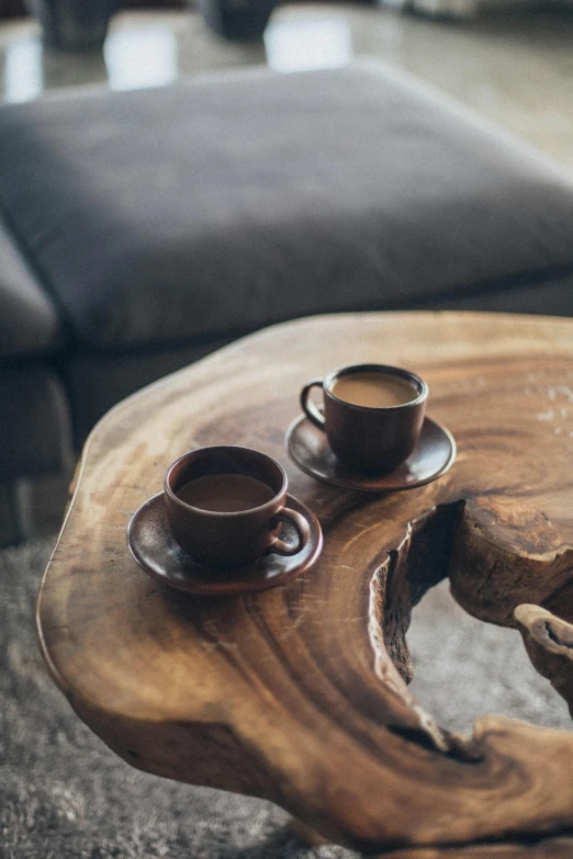 a coffee table with two cups on top of it, by Jesper Knudsen, trending on unsplash, tree stump, brown color palette, multiple stories, colombian