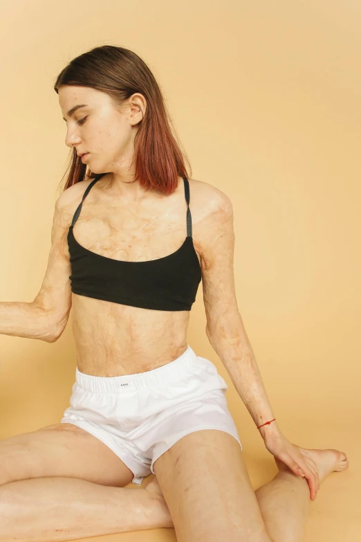 a woman sitting in the middle of a yoga pose, an album cover, by Ellen Gallagher, trending on unsplash, figuration libre, human skin texture, bra and shorts streetwear, very vascular, looks a blend of grimes