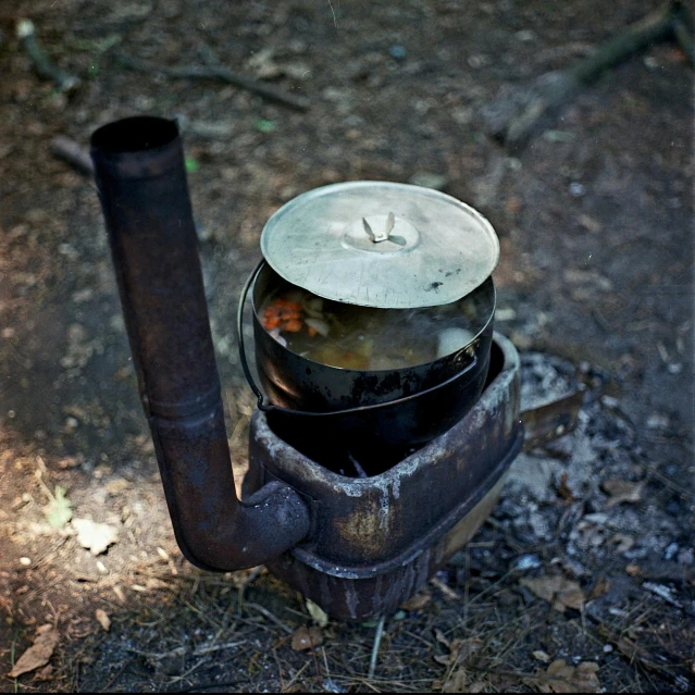 a pot that is sitting on top of a stove, by Slava Raškaj, photograph captured in the woods, leaking pistons, [ metal ], pipe