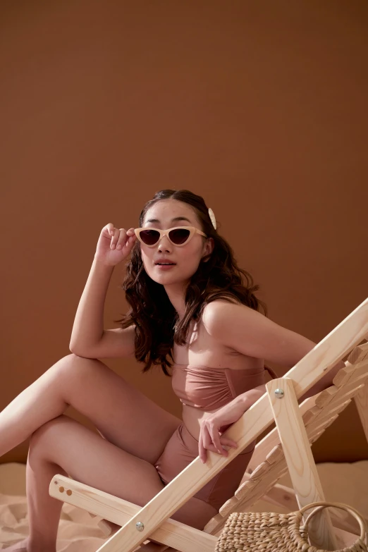 a woman sitting on top of a wooden chair, sunglasses on, pastel pink skin tone, gongbi, 5 0 0 px models