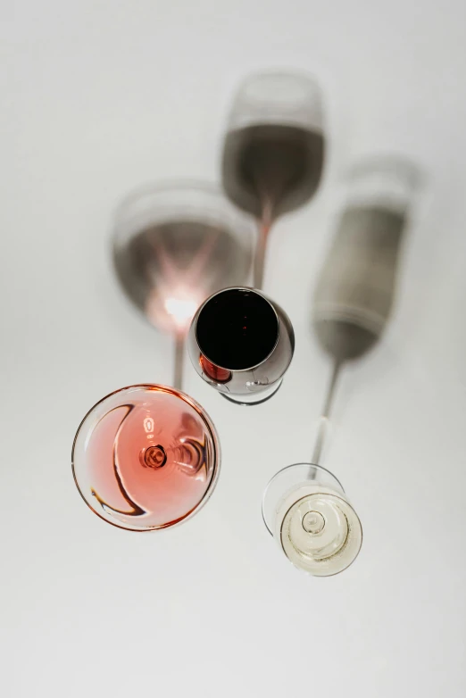 a couple of wine glasses sitting next to each other, floating metallic objects, wide overhead shot, zoomed in, curated collections