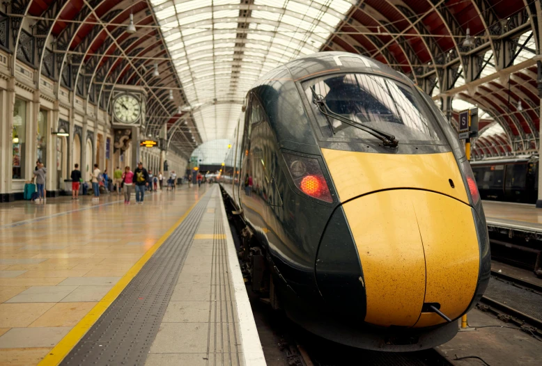 a yellow and black train pulling into a train station, pexels contest winner, bath, avatar image, high speed trains, advert