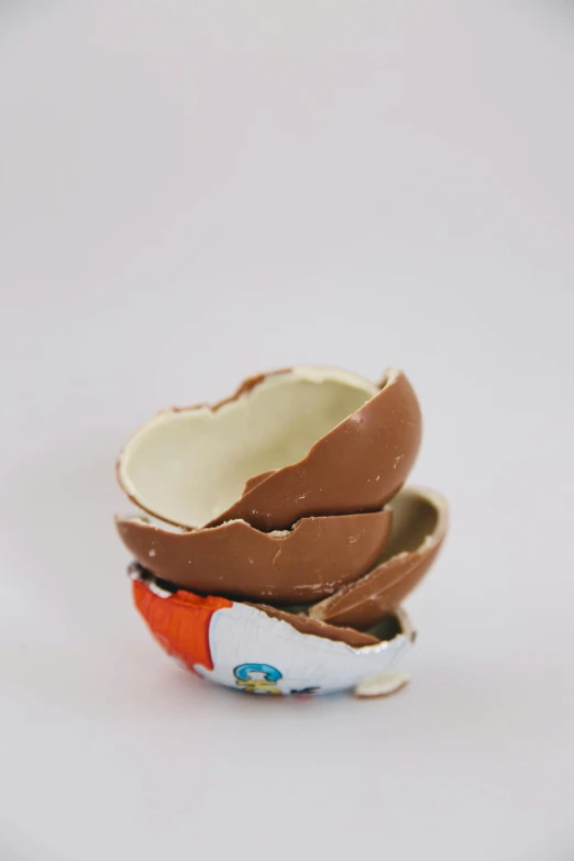 a broken egg sitting on top of a white table, an album cover, by Matthias Stom, unsplash, sculpted out of candy, destroyed, fully chocolate, ilustration