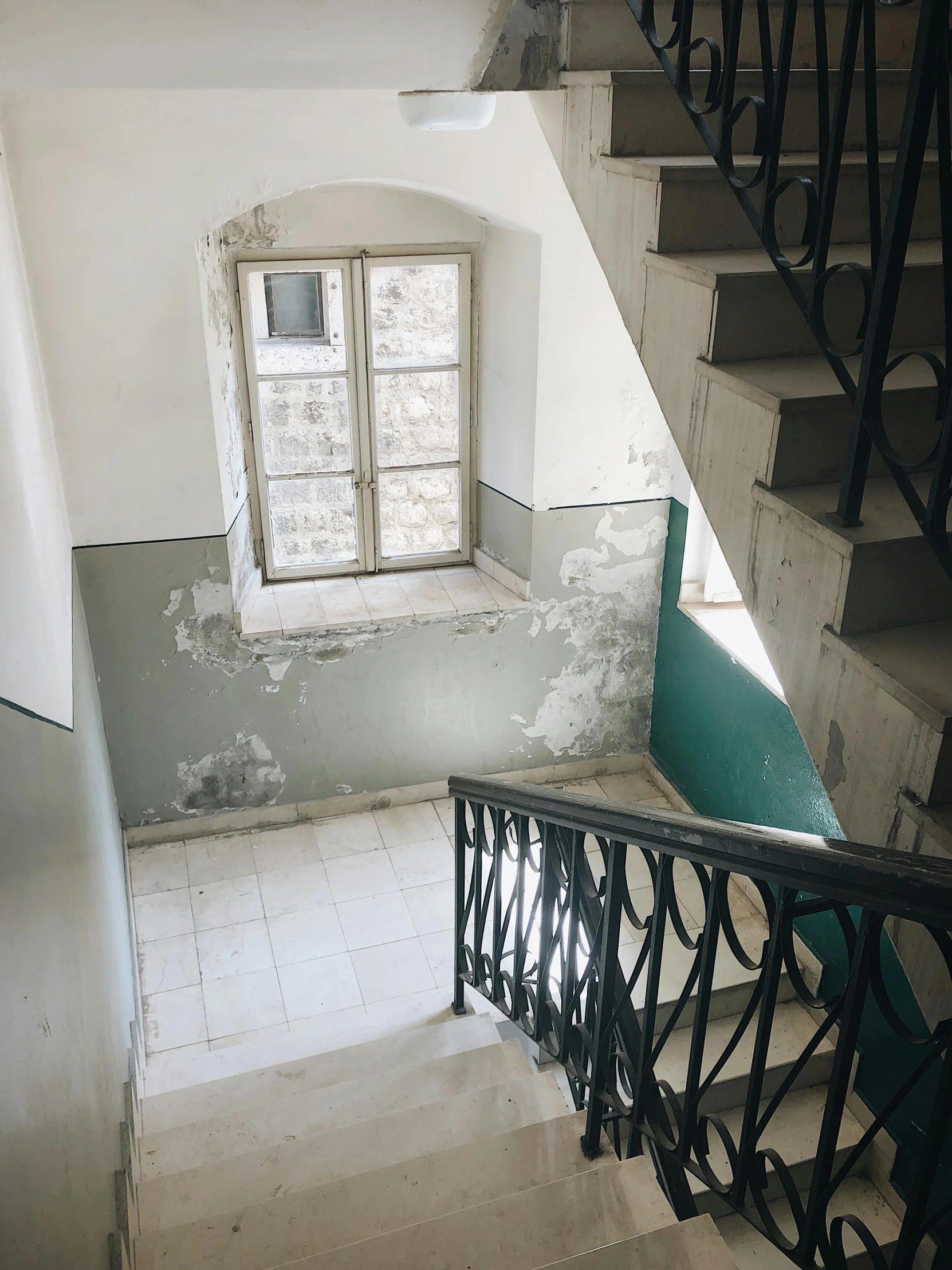 a staircase leading up to a window in a building, photo of poor condition, before a stucco wall, julia sarda, low quality photo