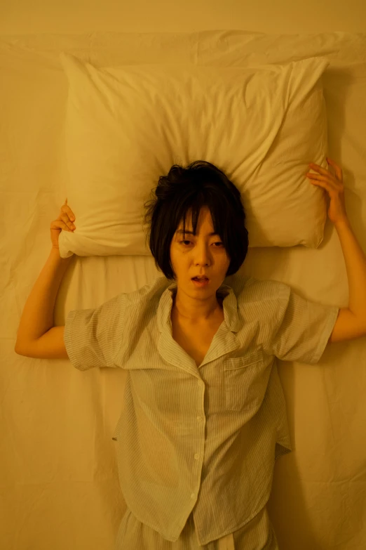 a woman laying on top of a bed covered in pillows, inspired by Nan Goldin, unsplash, hyperrealism, japanese live-action movie, movie still of a snarling, 奈良美智, scene from a movie