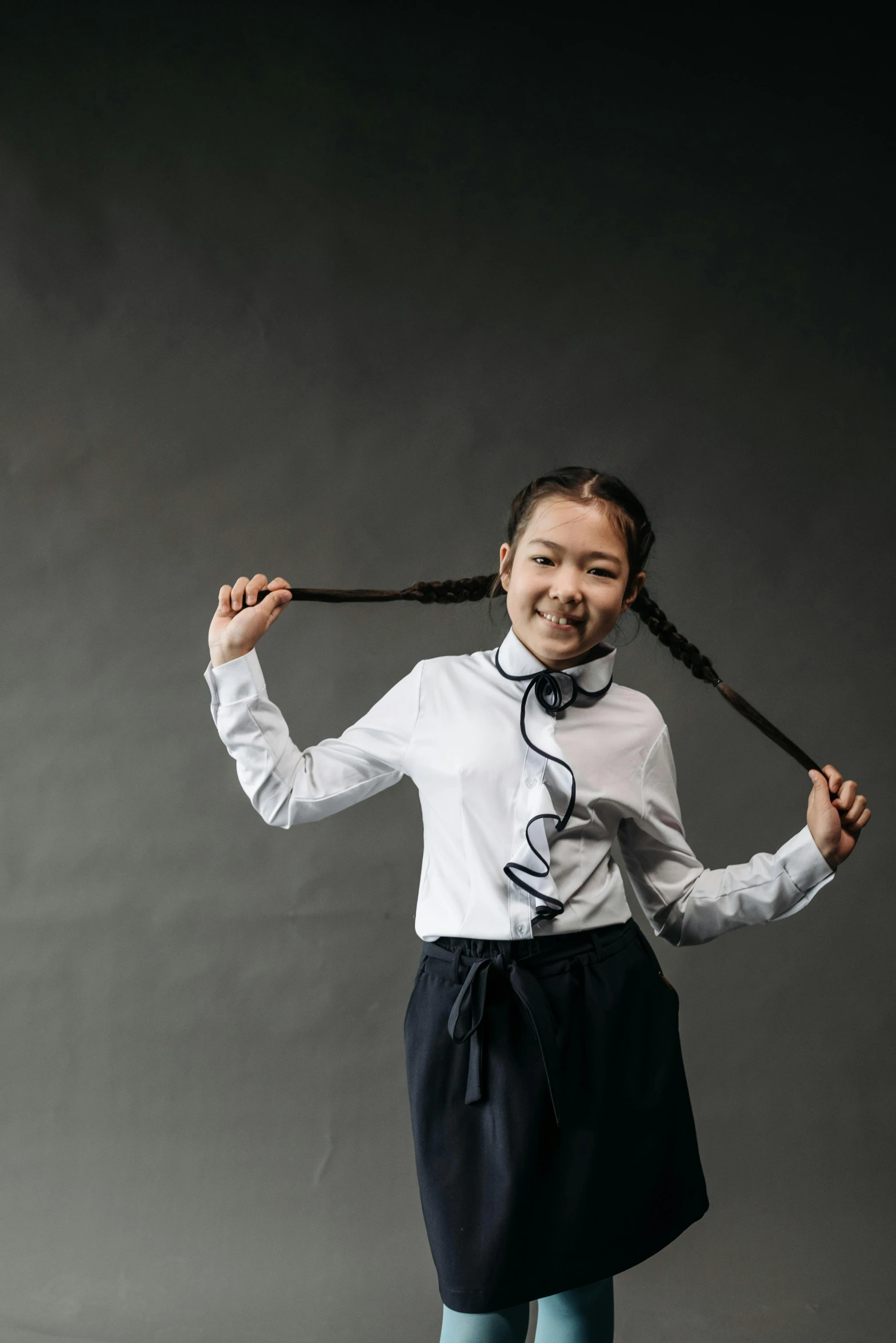 a young girl in a white shirt and black skirt, inspired by Kim Tschang Yeul, pexels contest winner, hair are wired cables, bjork smiling, ribbon in her hair, inuit