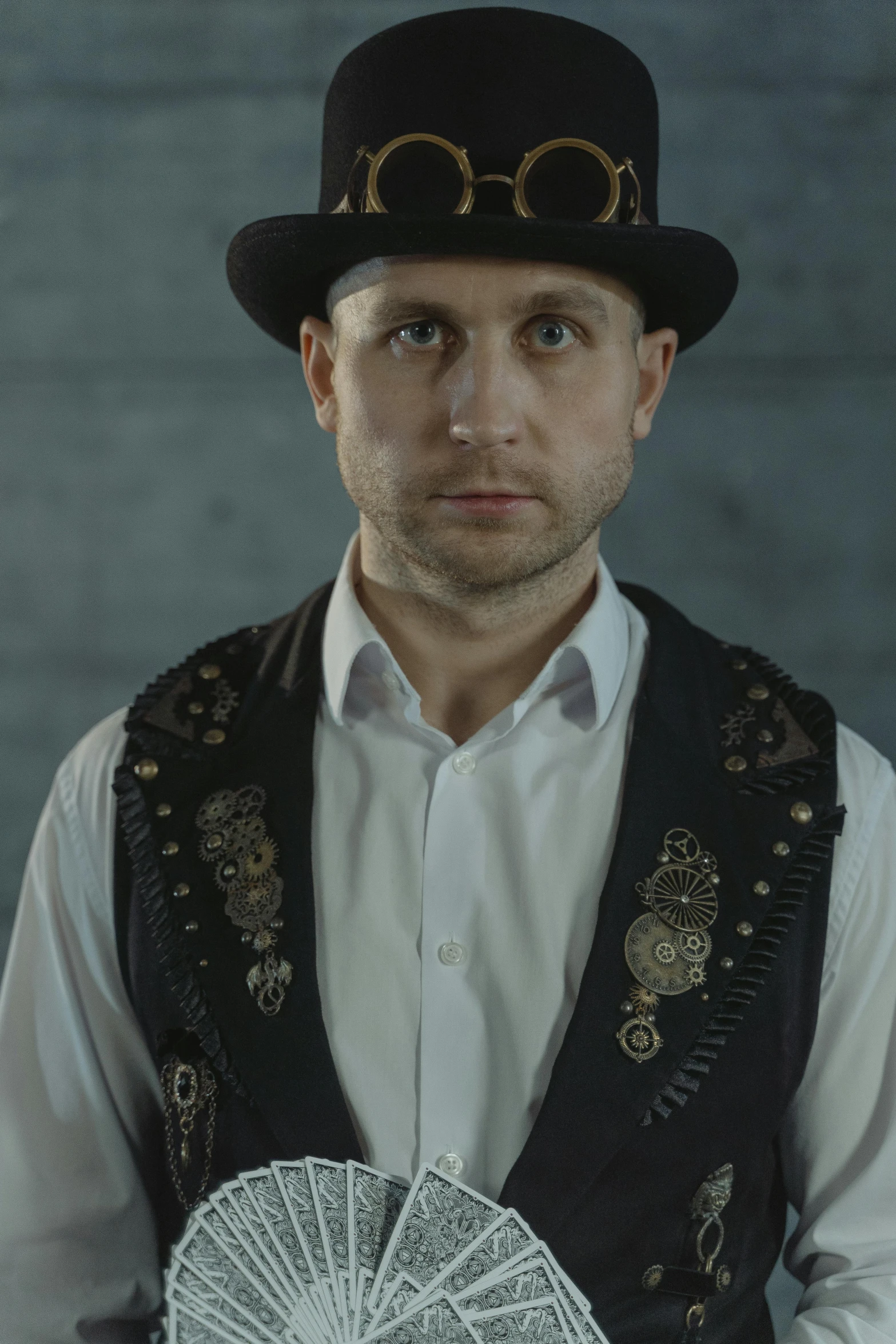 a man in a top hat holding a fan, inspired by Karl Völker, reddit, renaissance, model is wearing techtical vest, wearing many medallions, close-up portrait film still, jakub rebelka