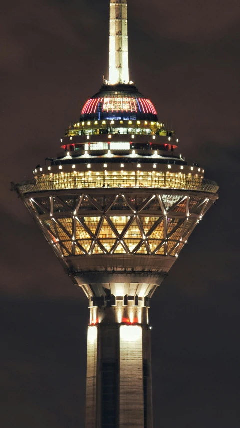 a very tall tower lit up at night, by Dave Allsop, demur, round-cropped, seventies, observation deck