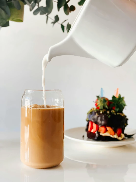 a person pouring milk into a glass next to a plate of food, profile image, birthday cake, iced latte, thumbnail