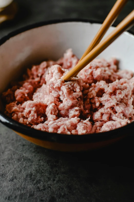 a bowl of ground beef with chopsticks in it, a portrait, unsplash, process art, pink, kete butcher, slightly tanned, caucasian