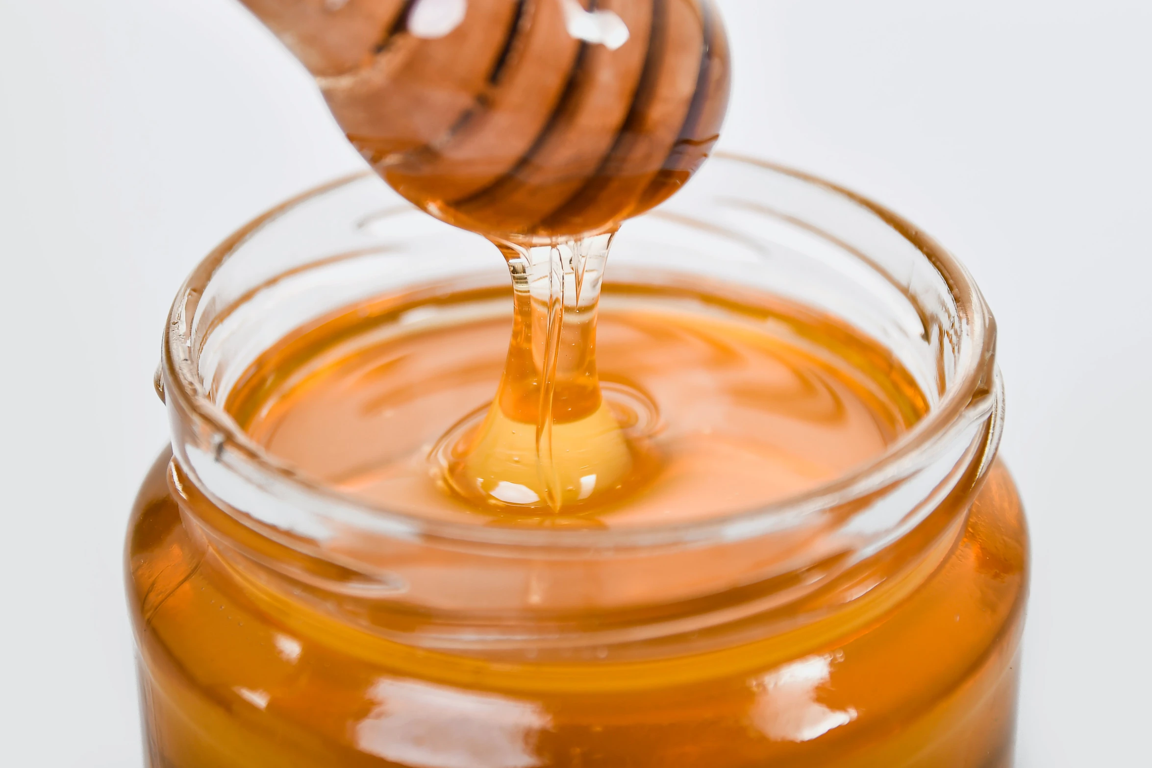 a jar of honey with a wooden stick sticking out of it, trending on pexels, hurufiyya, close up high detailed, pouring, thumbnail, hexagonal shaped